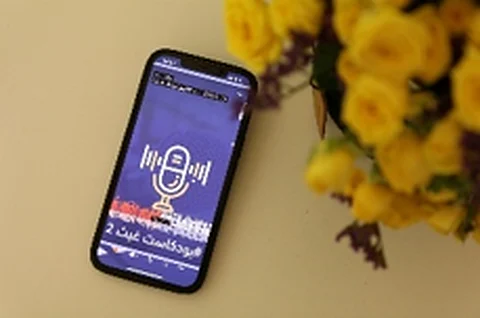 هاتف يعرض بودكاست غيث بجانب باقة ورد